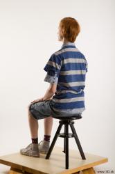 Sitting reference of whole body striped blue gray shirt blue jeans shorts black gray shoes Wesley